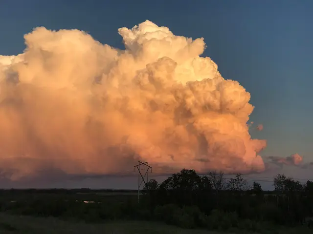 Towering storm cloud at sunset over the prairie